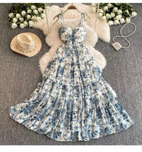 Floral dress on a hanger with a hat, bag, and flowers on a textured surface