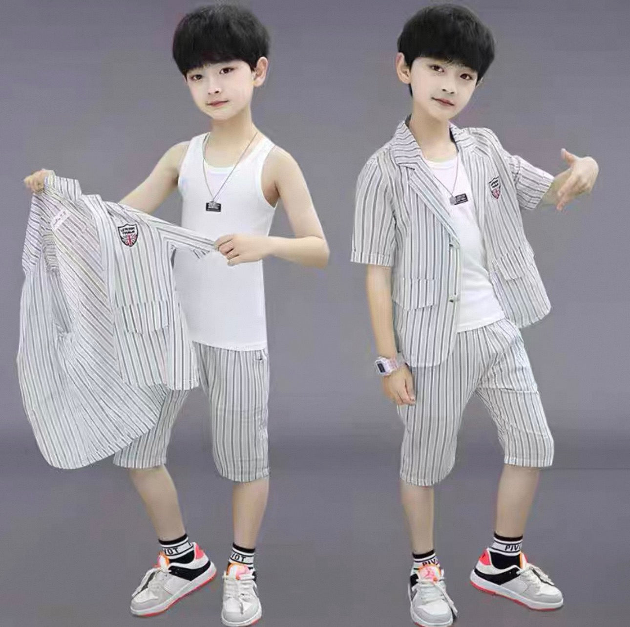 Two children modeling a striped suit set against a gray background