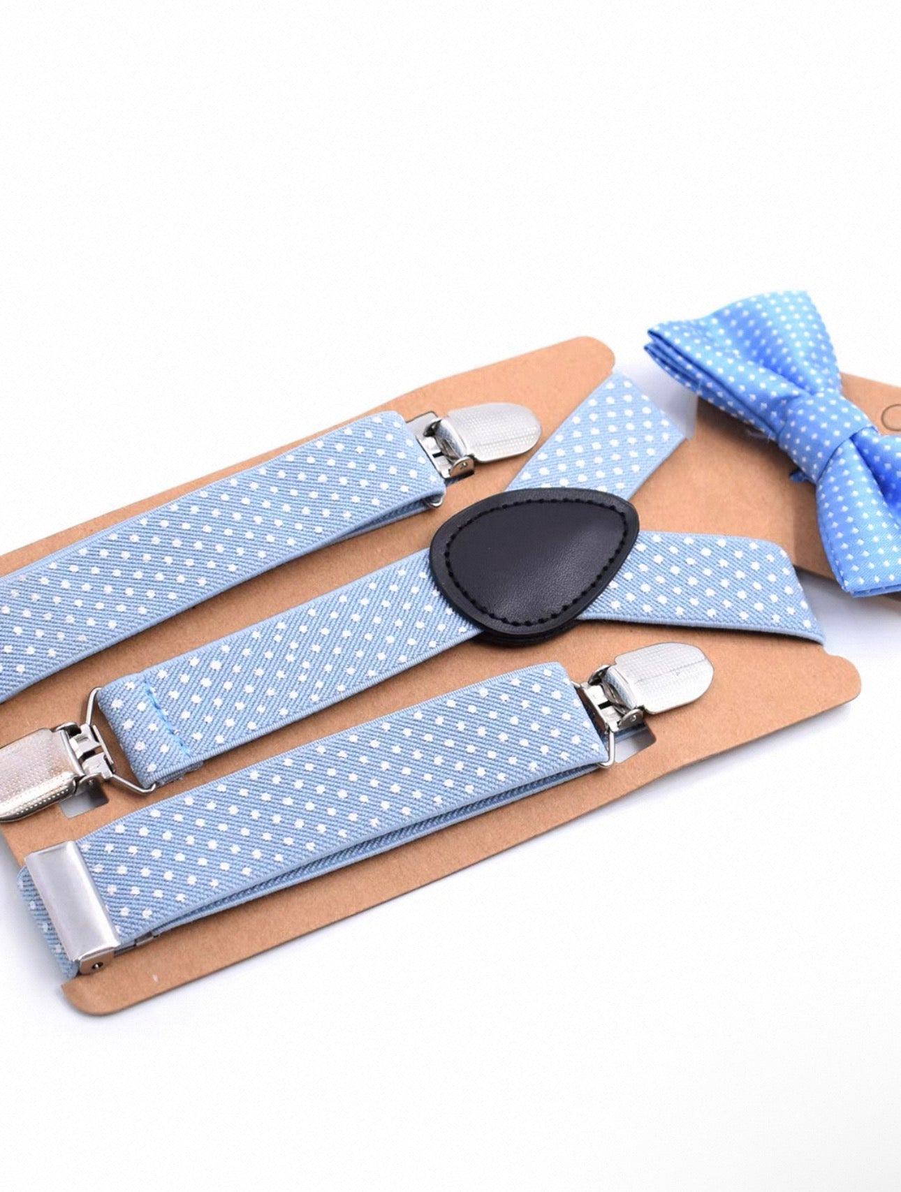 Blue polka dot suspenders and bow tie set on a white background