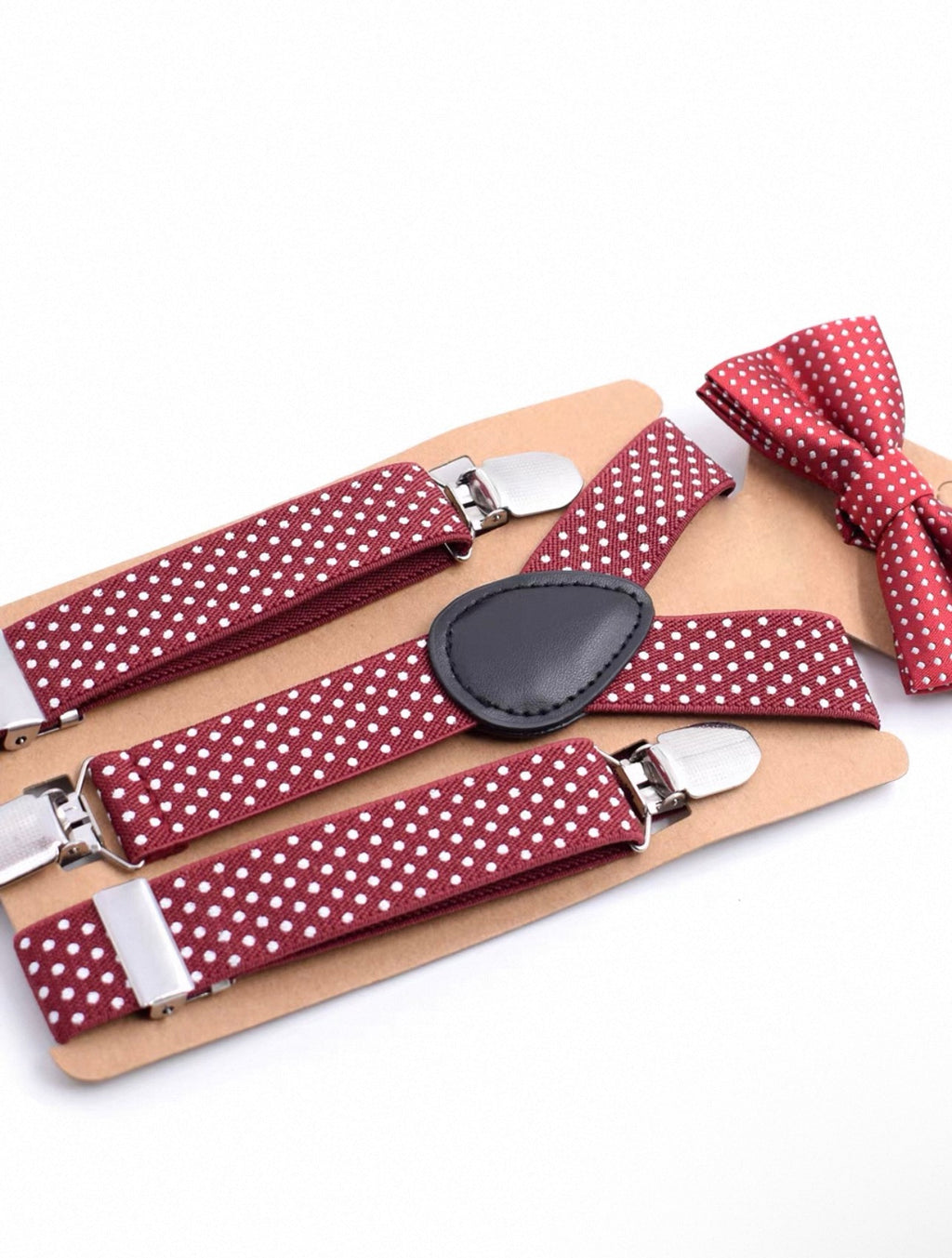 Red polka dot suspenders and bow tie set on a white background