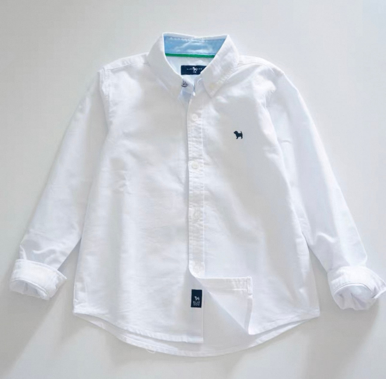 White button-up shirt with brand logo on a light gray background