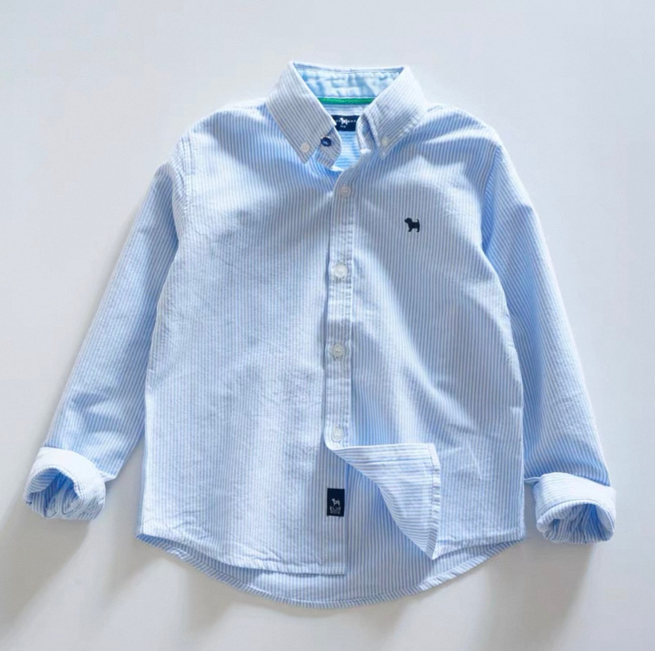 Blue striped shirt with brand logo on a light gray background