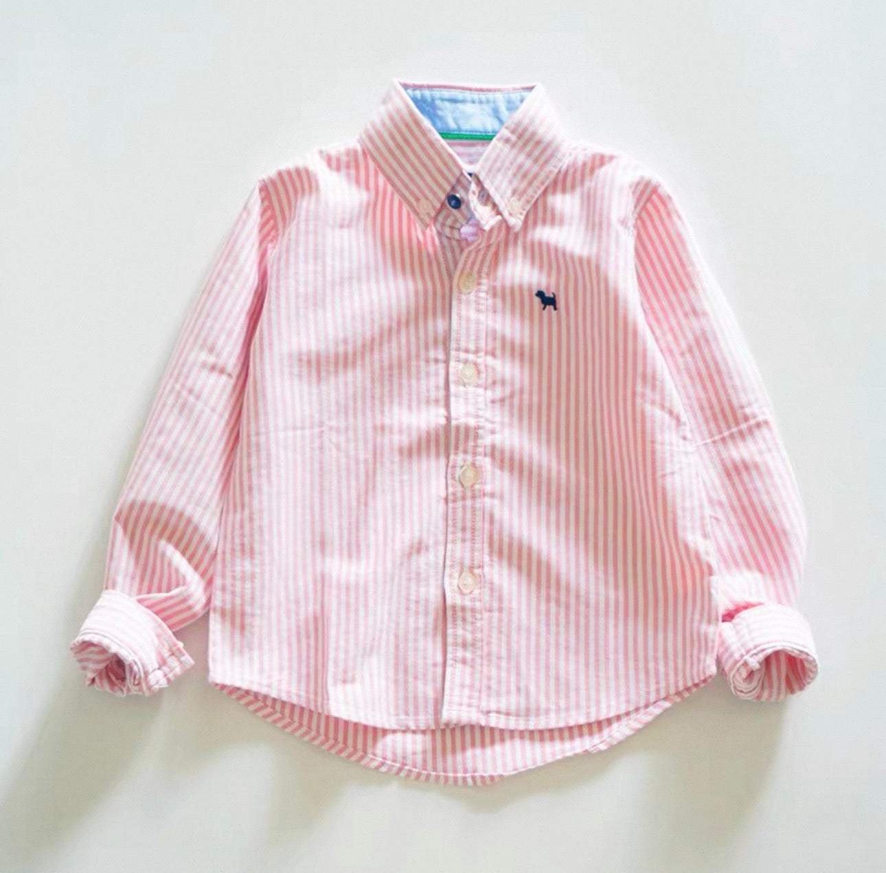 Pink and white striped shirt on a light gray background