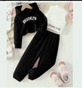 Black 'Brooklyn' sweatshirt and pants set with pink shoes on a floral background