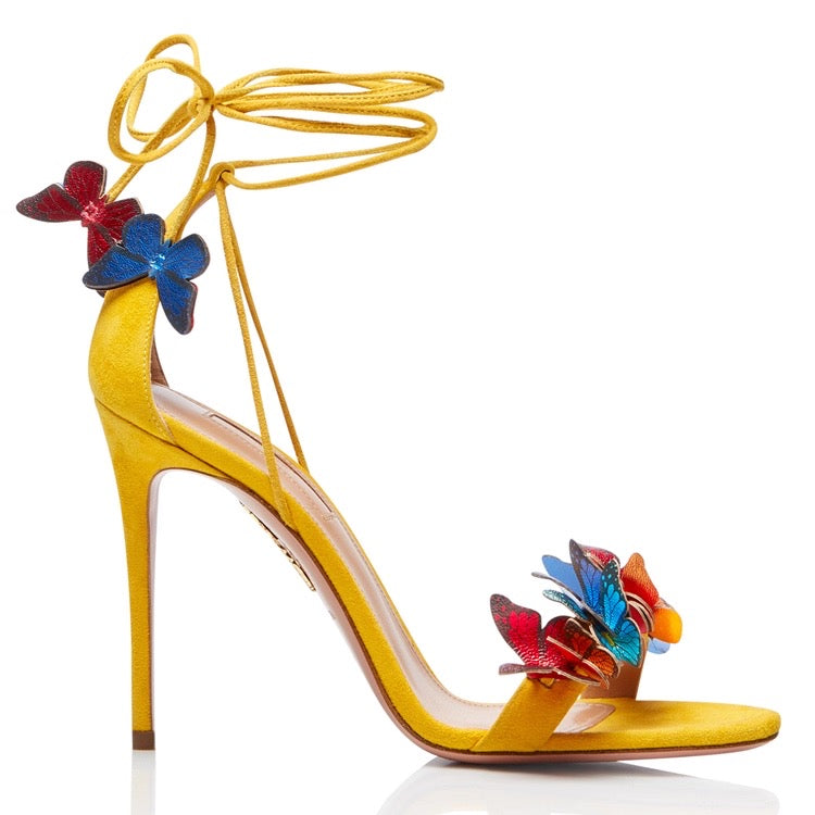 Yellow stiletto high heel sandal with ankle wrap straps and multicolor butterfly and flower decorations on front and side.