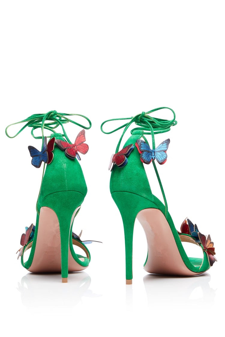 Green suede stiletto heels with butterfly and flower accents, ankle wrap straps.