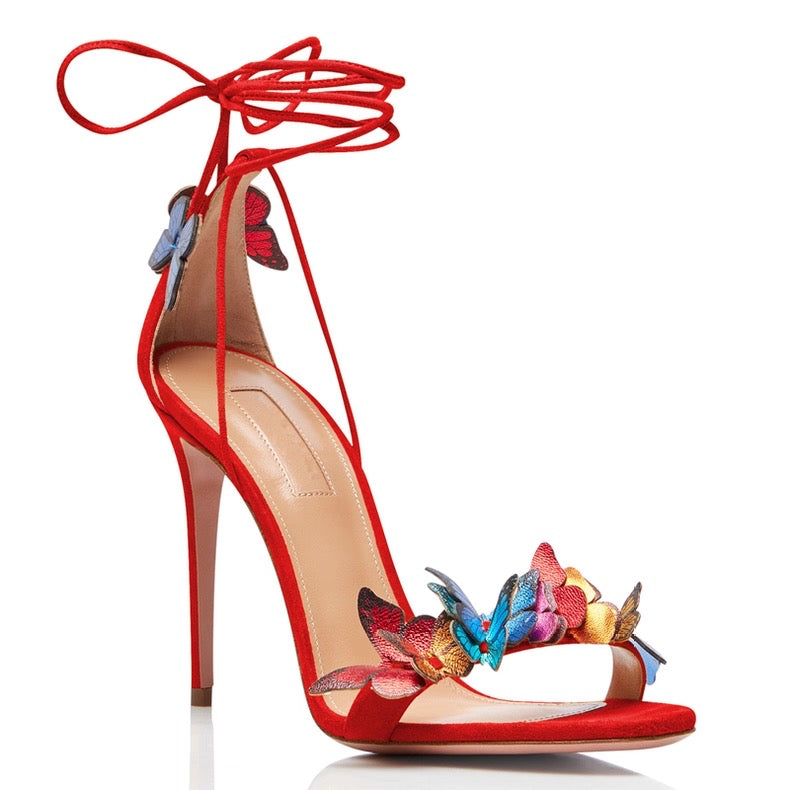 Red stiletto high heel sandal with ankle wrap straps and colorful butterfly embellishments on front strap.