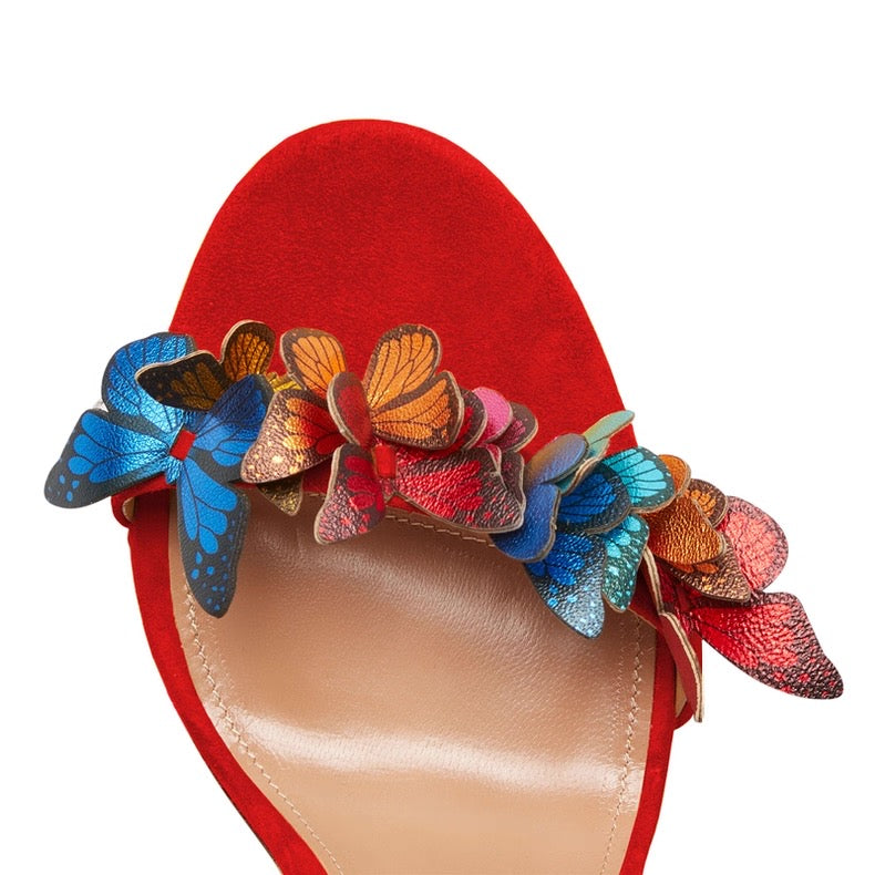 Red suede high heel sandal with colorful butterfly appliques on one strap.