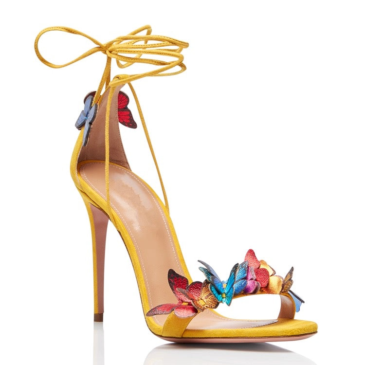 Yellow stiletto high heel sandal with butterfly accents and ankle wrap straps.