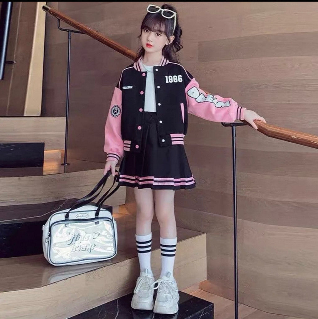 Person wearing a black and pink varsity jacket with a white bag on a wooden staircase.