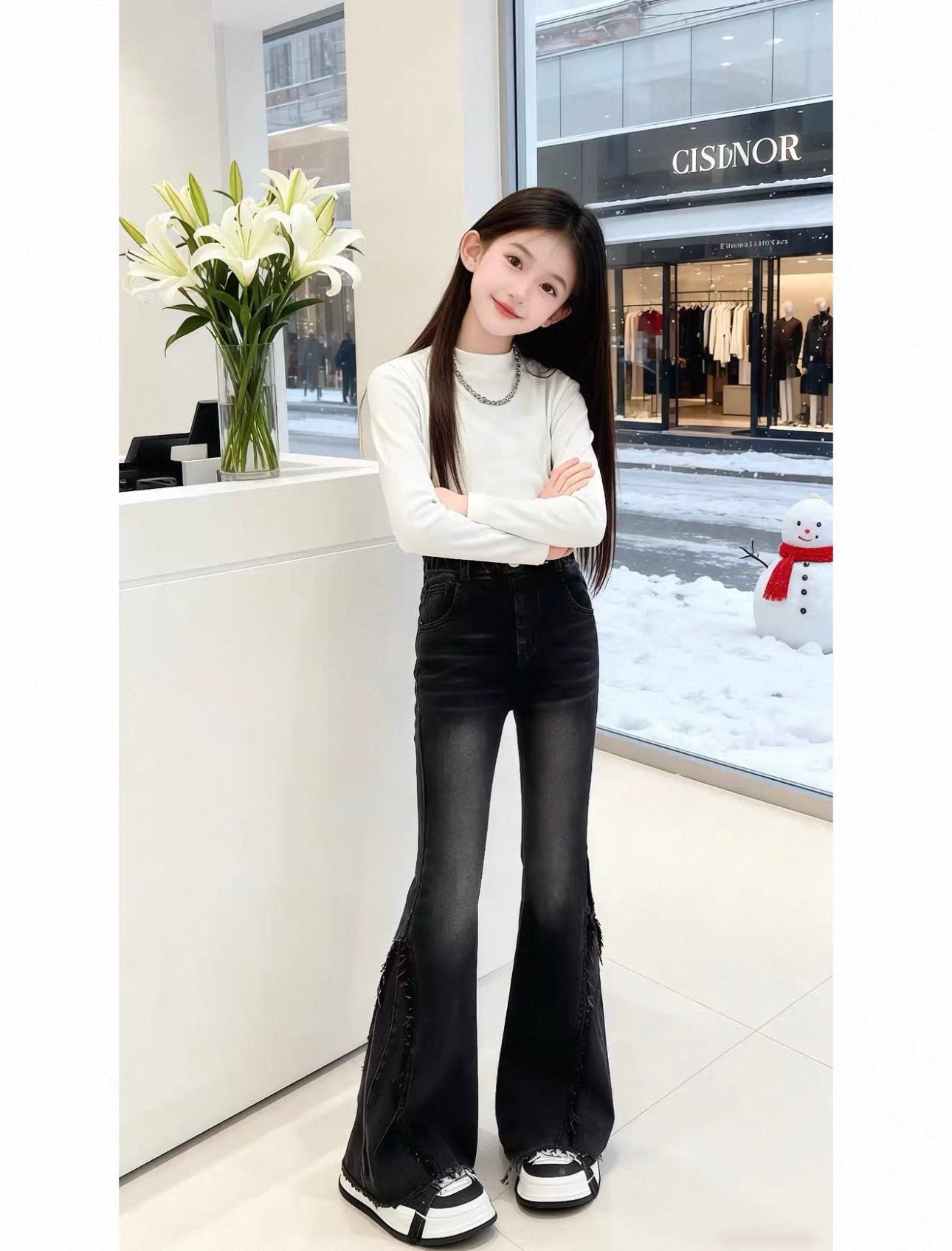 Person wearing a white long-sleeve top and black flared jeans standing in a store with a snowman decoration outside.