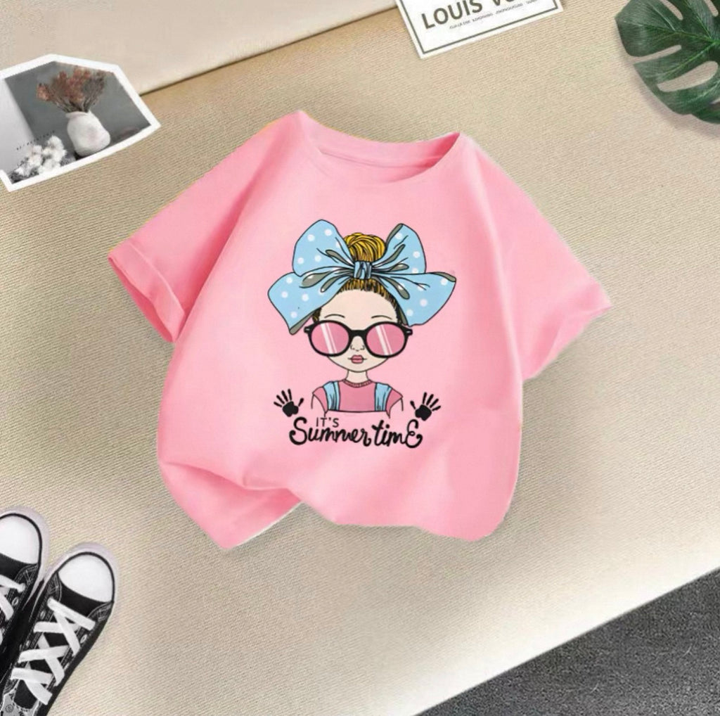 Pink t-shirt with a graphic design of a girl with a bow and sunglasses on a beige surface.