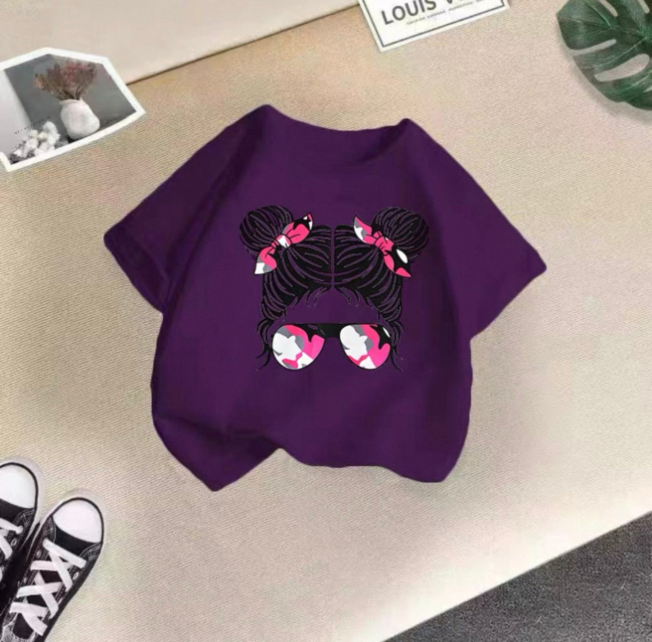 Purple sweatshirt with a graphic design on a beige surface