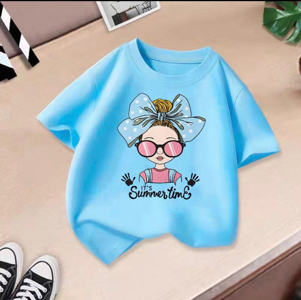 Blue t-shirt with a cartoon character and 'It's Summertime' text on a beige surface.