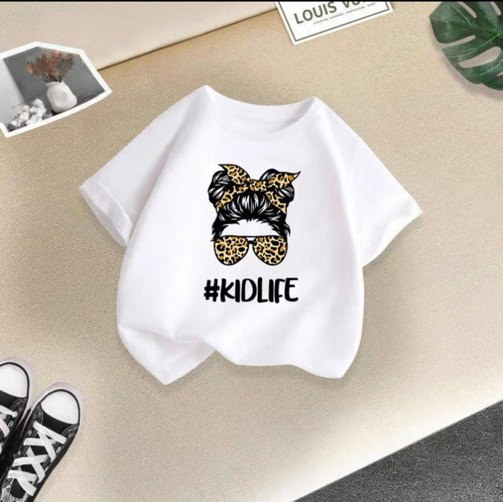 White t-shirt with '#KIDLIFE' graphic on a beige surface