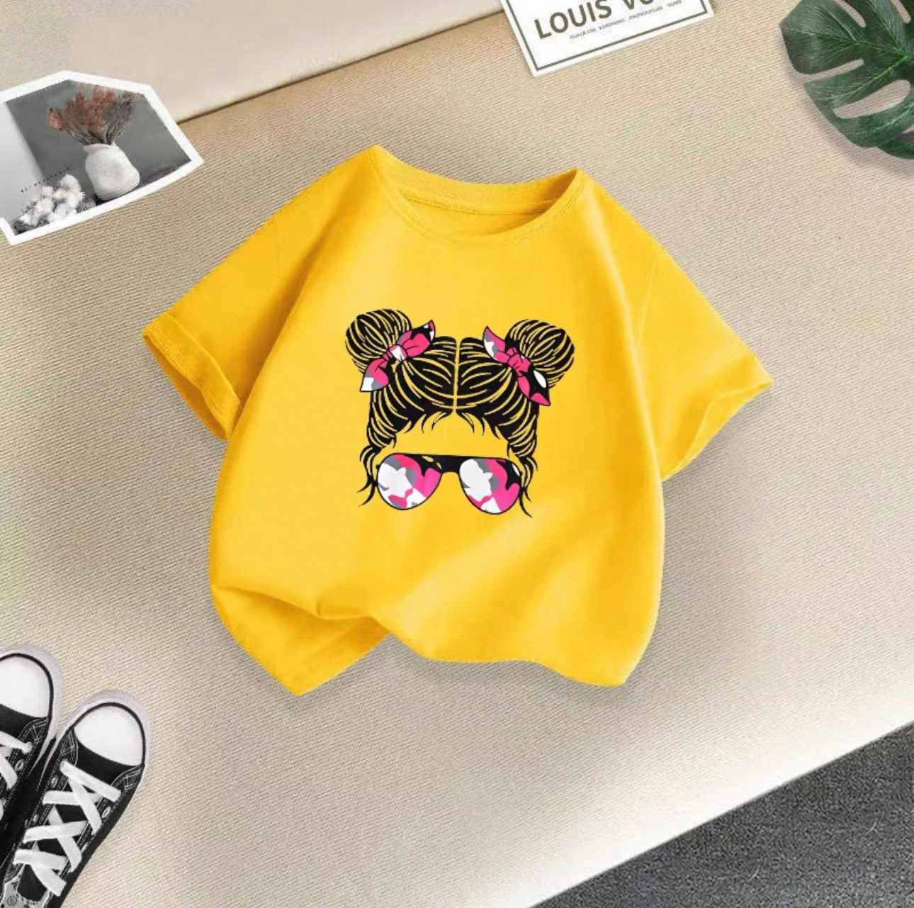 Yellow sweatshirt with a graphic design on a beige surface