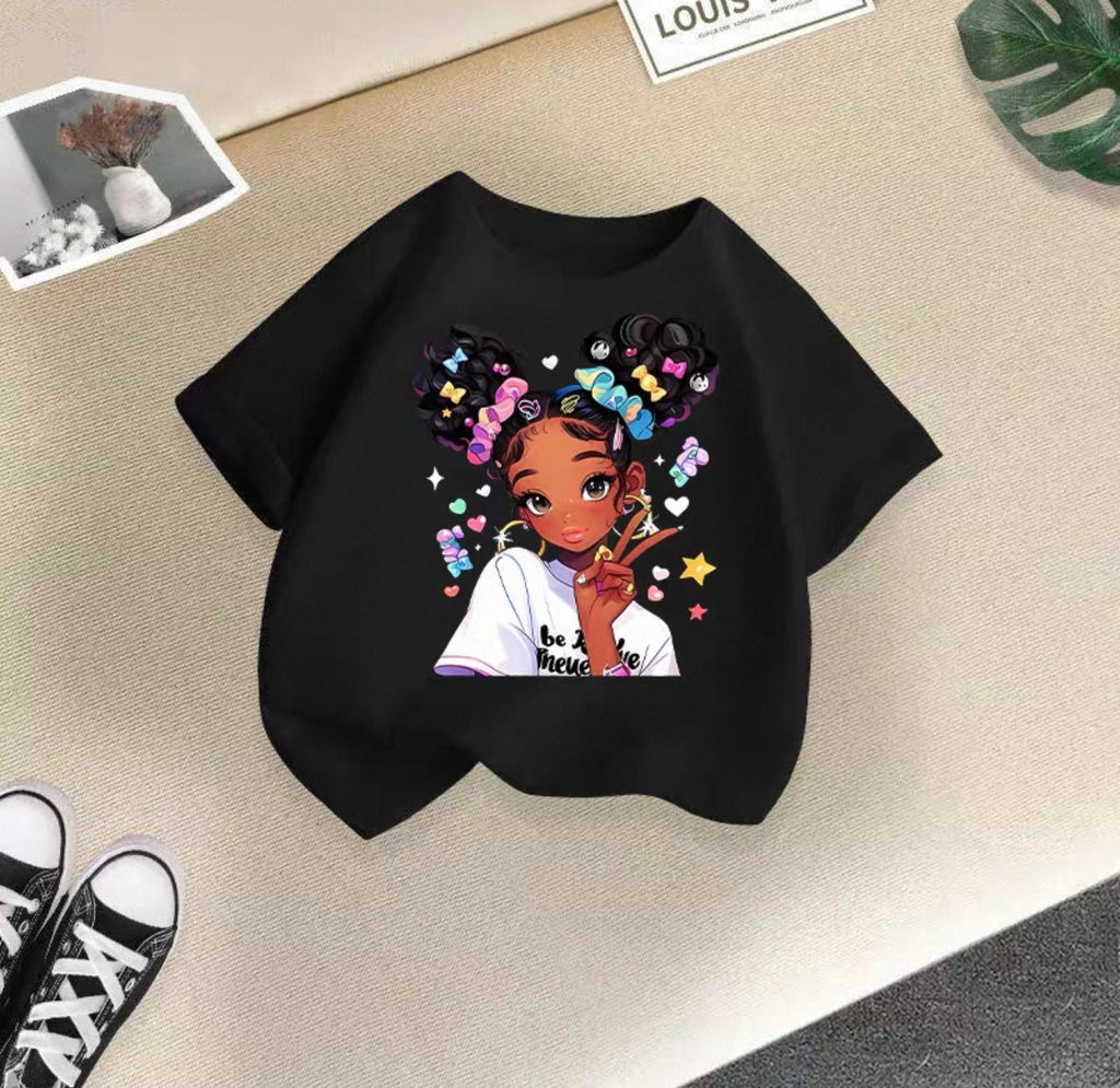 Black t-shirt with a colorful graphic of a girl on a beige surface.