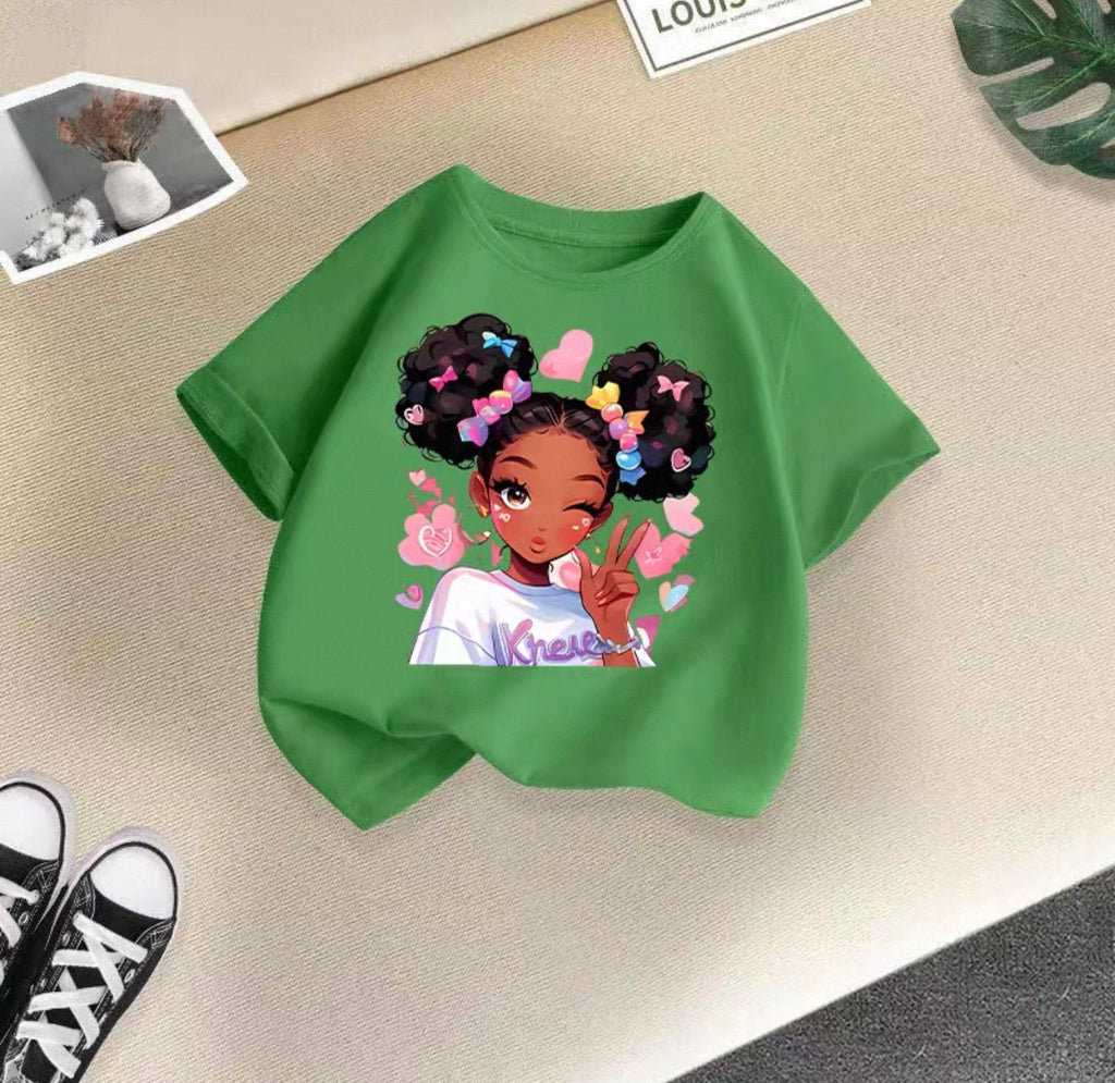 Green t-shirt with a graphic of a girl with flowers in her hair on a beige surface.