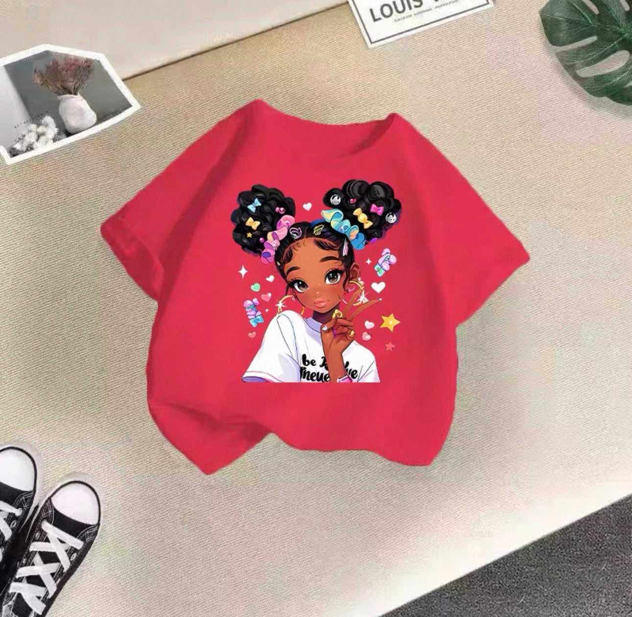 Red sweatshirt with an illustration of a girl on a beige surface
