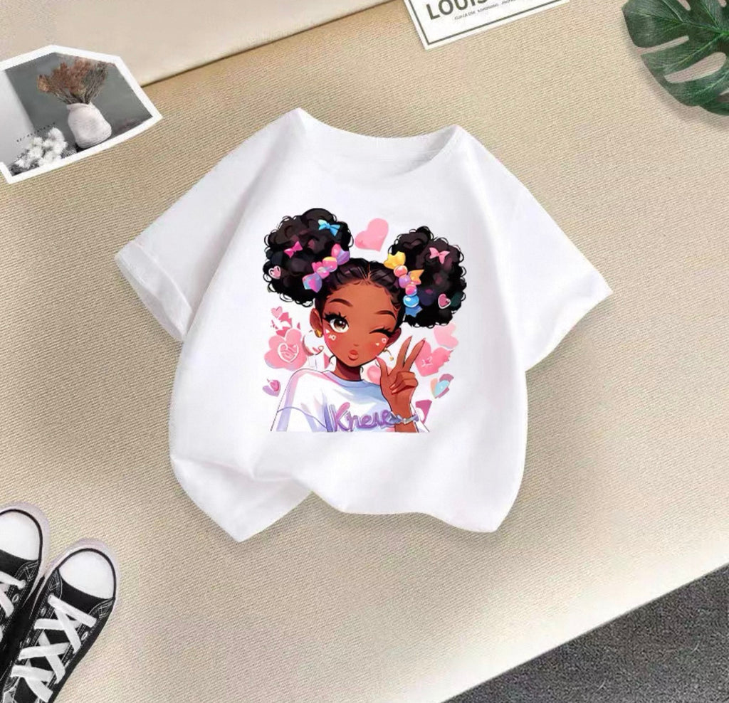 White t-shirt with a colorful graphic of a girl on a beige surface.