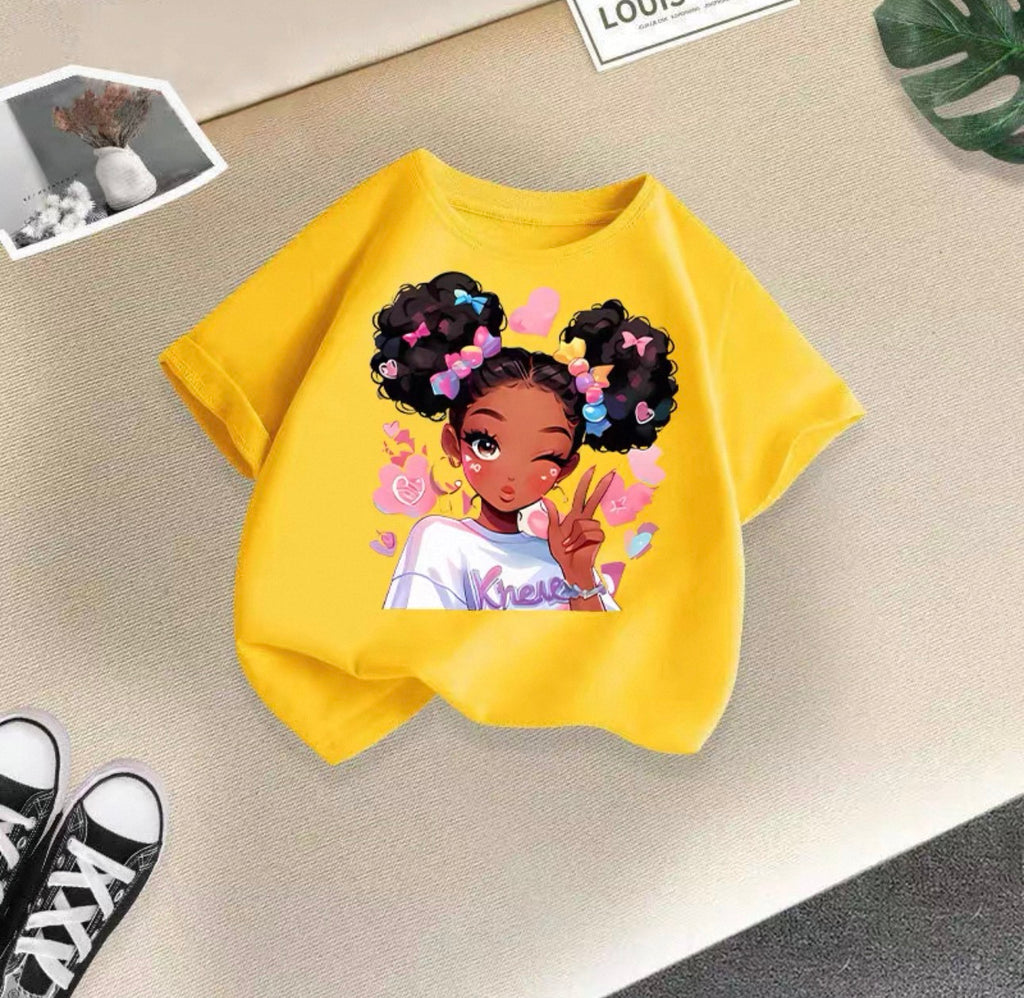 Yellow t-shirt with a graphic of a girl with styled hair on a beige surface.