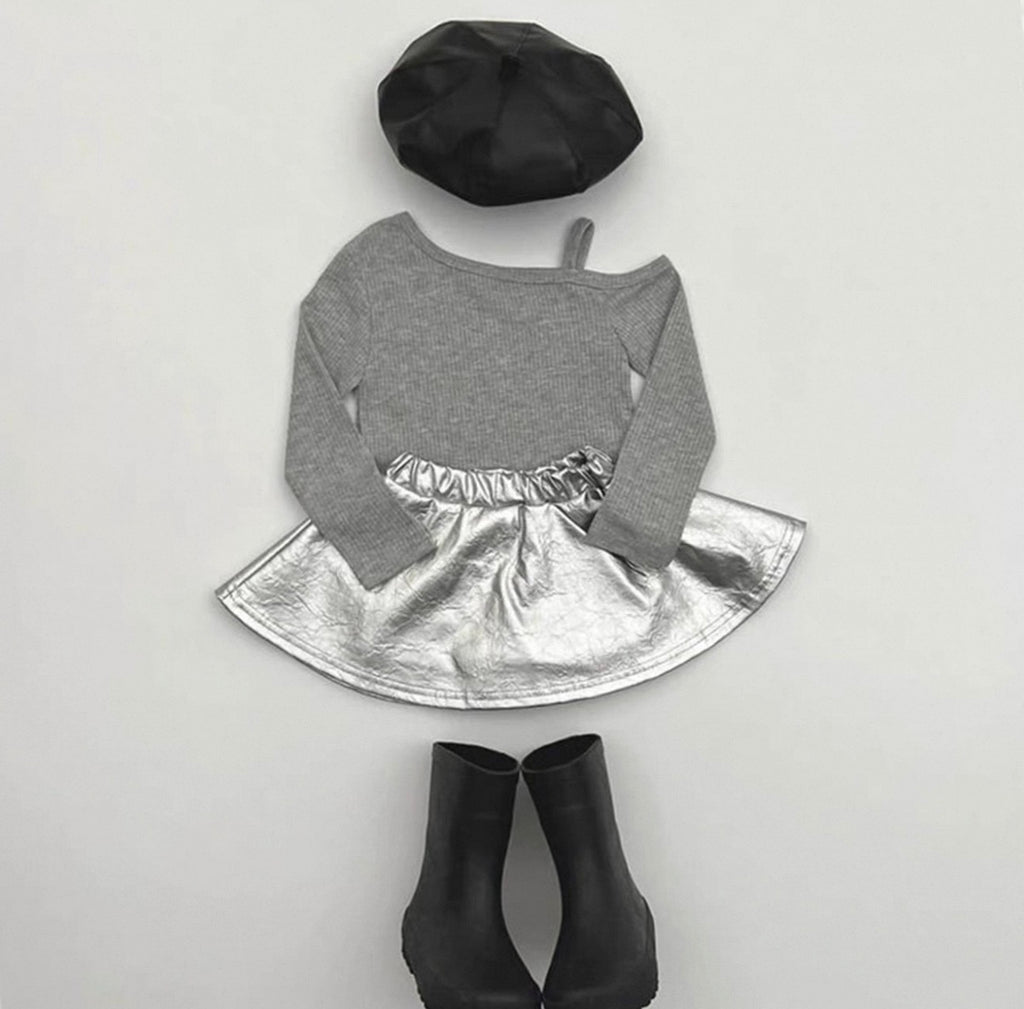 Gray long-sleeve top with silver skirt, black beret, and black ankle boots on a light gray background