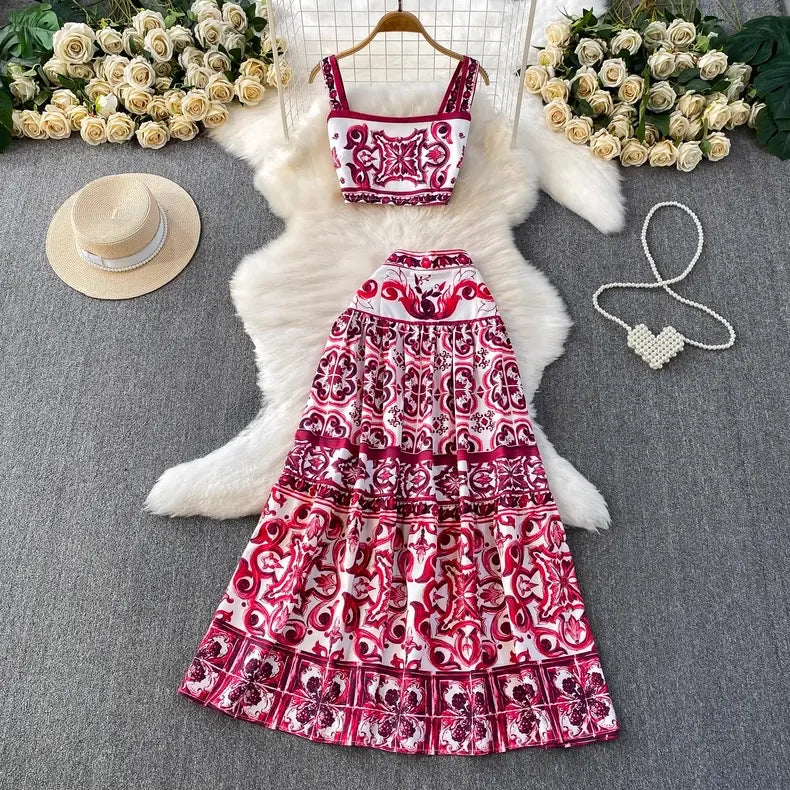 Red and white patterned dress on a hanger with flowers and a hat in the background