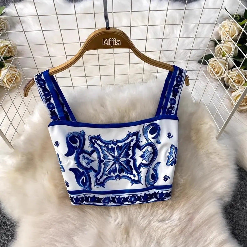 White top with blue patterns on a hanger against a white grid background