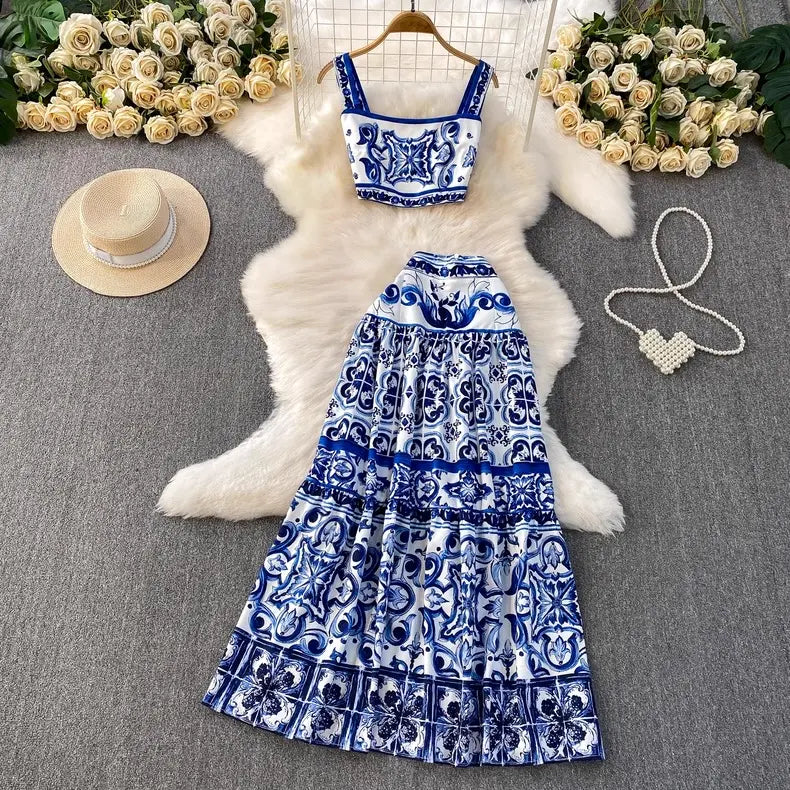 Blue and white patterned dress on a hanger with flowers and a hat in the background