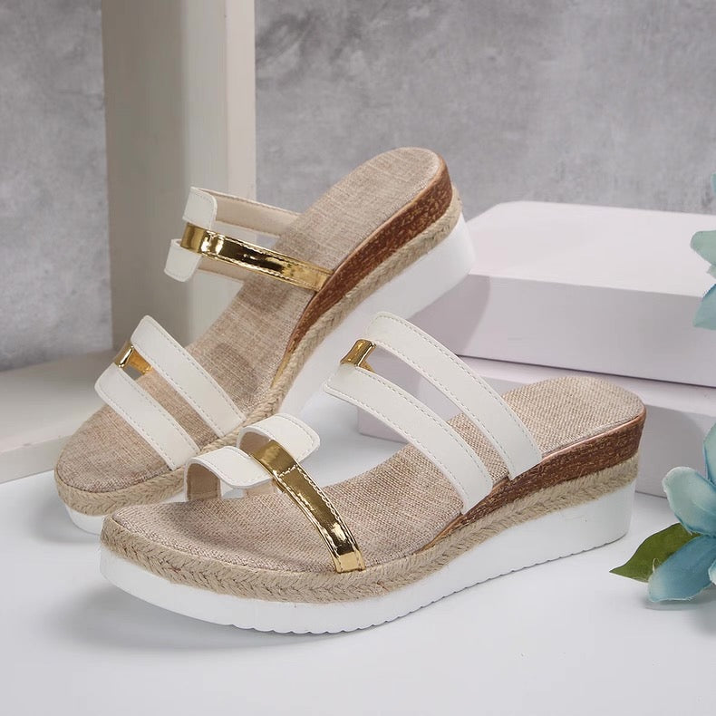 Beige and white sandals with gold accents on a light background