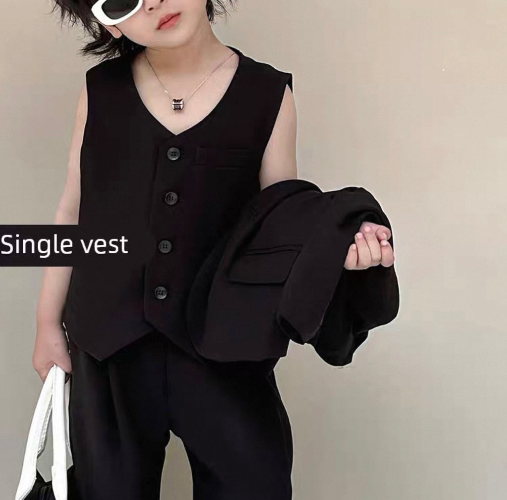 Person wearing a black vest over a black shirt with a plain background