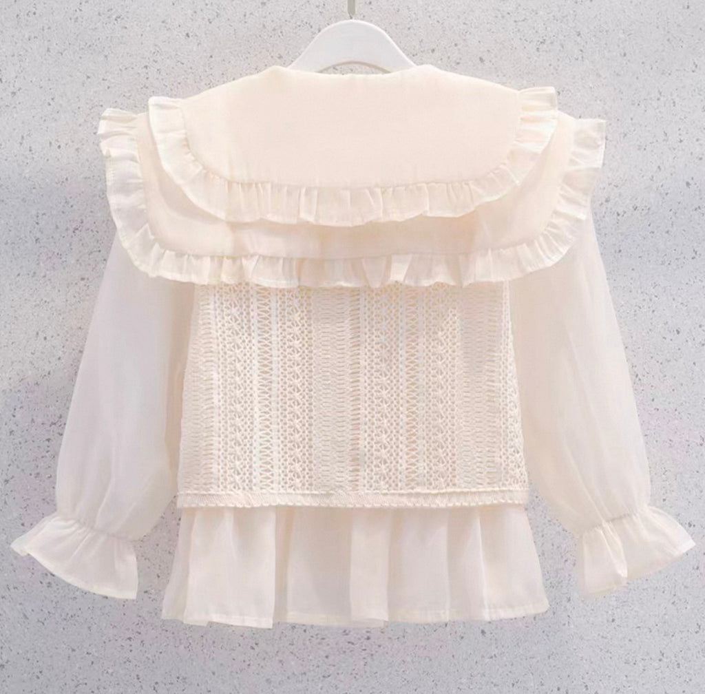 White blouse with ruffled details on a gray background