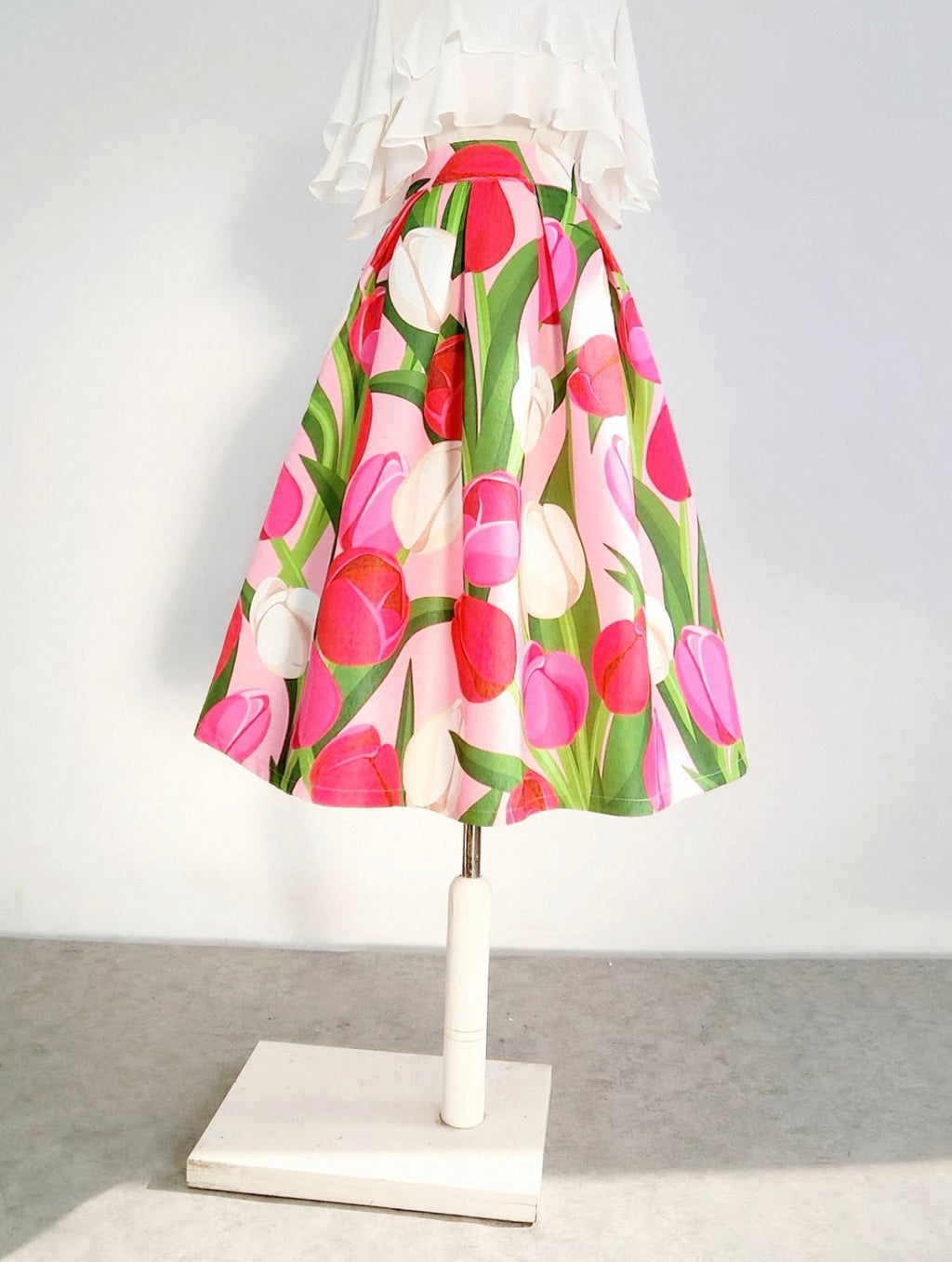 Floral skirt on a mannequin against a white background